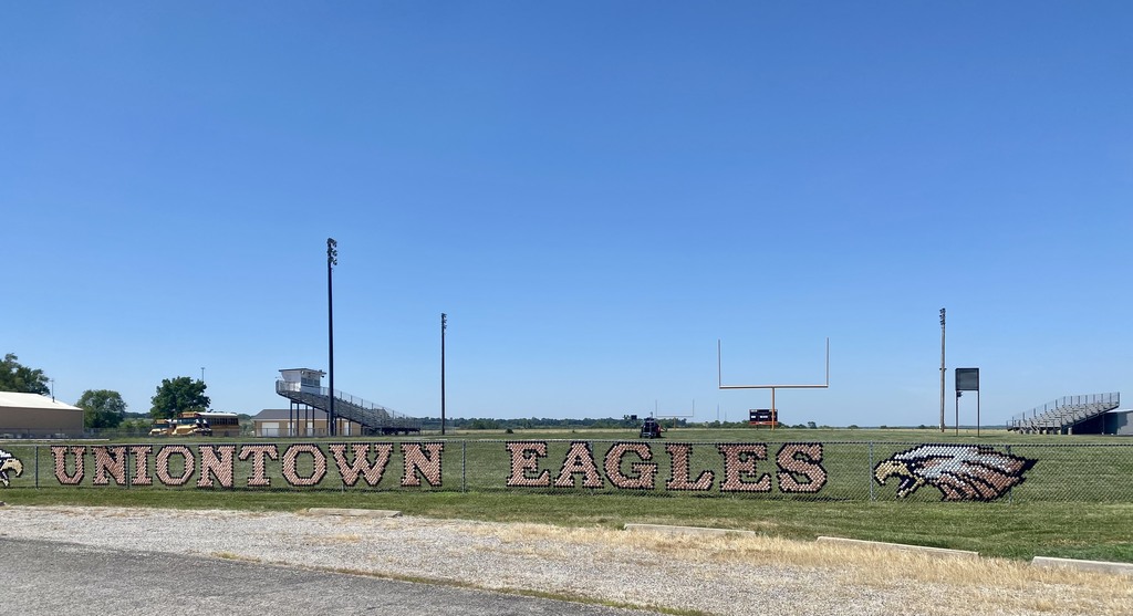 Picture of the Uniontown Eagles on fence by the football field