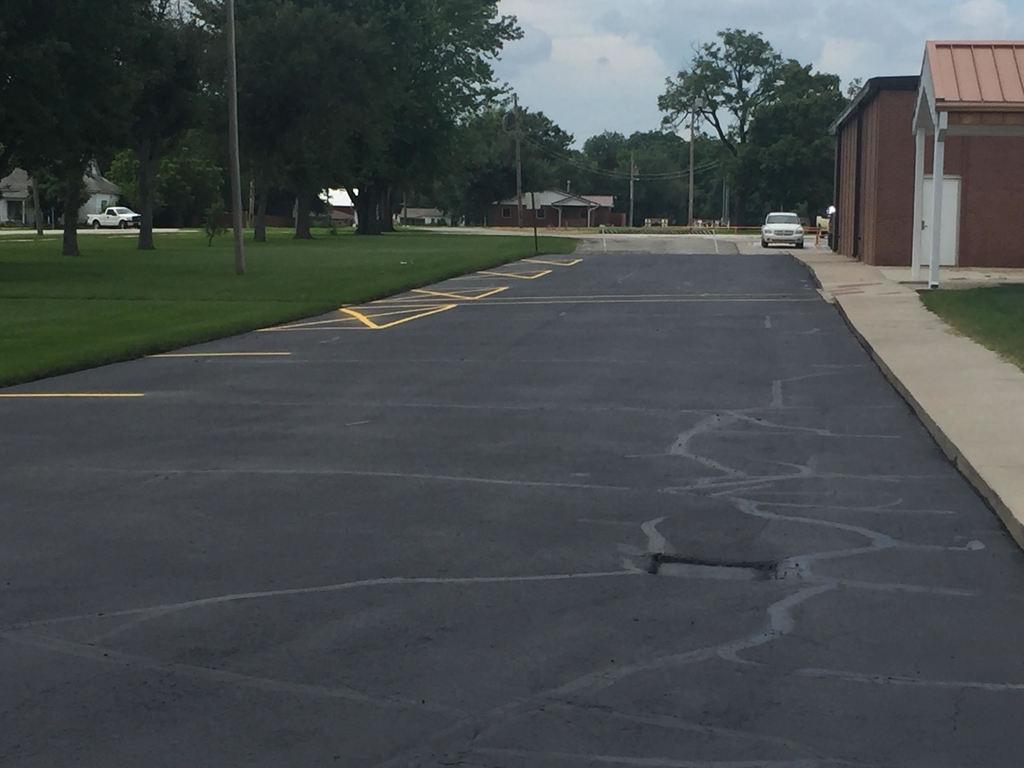 Parking lot is sealed and repainted to the end of where buses load at the JH/HS.