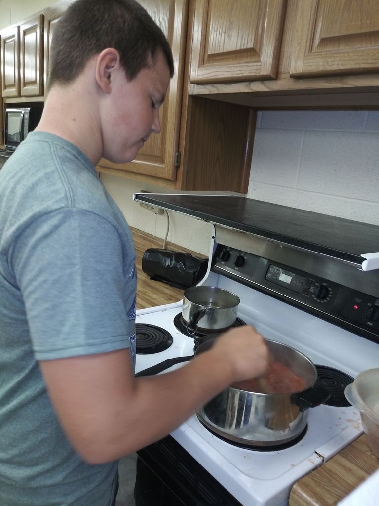 A student stirring the salsa as it begins to thicken...getting close to being able to sample!